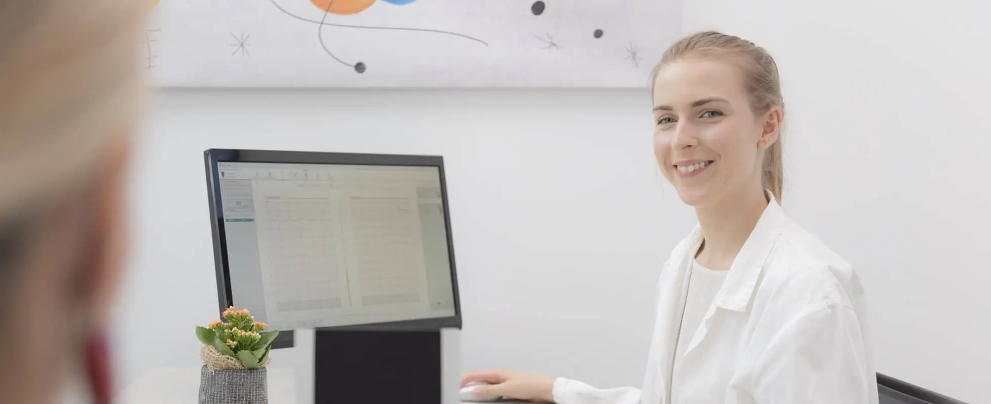 Image of an Audiologist at a computer - About Us banner image for Pure Tone Diagnostics